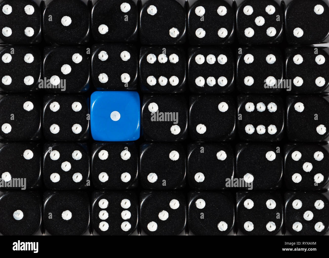 Sullo sfondo di un casuale nero ordinato plinti con un cubo blu Foto Stock
