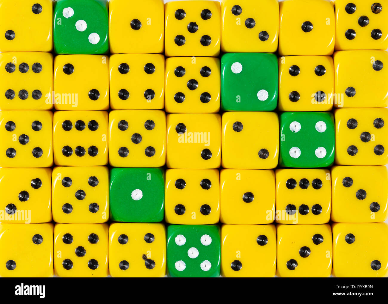 Sullo sfondo di un casuale giallo ordinato plinti con cinque cubetti di verde Foto Stock