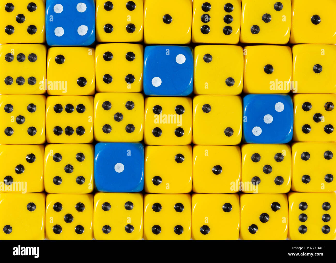 Sullo sfondo di un casuale giallo ordinato plinti con quattro cubi blu Foto Stock