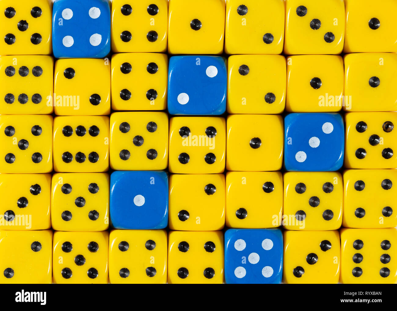 Sullo sfondo di un casuale giallo ordinato plinti con cinque cubetti di blu Foto Stock