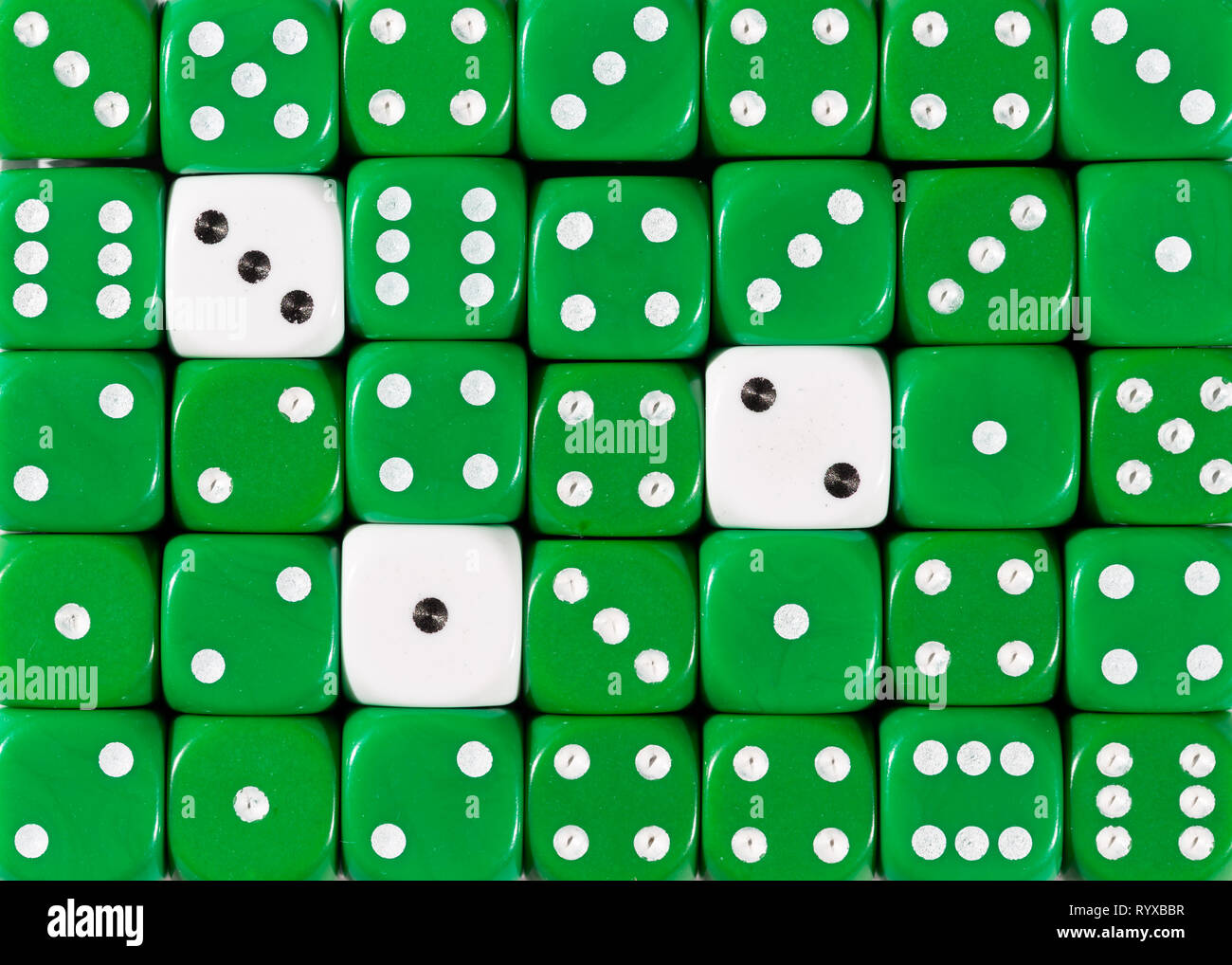 Sullo sfondo di un casuale verde ordinato plinti con tre cubi bianco Foto Stock