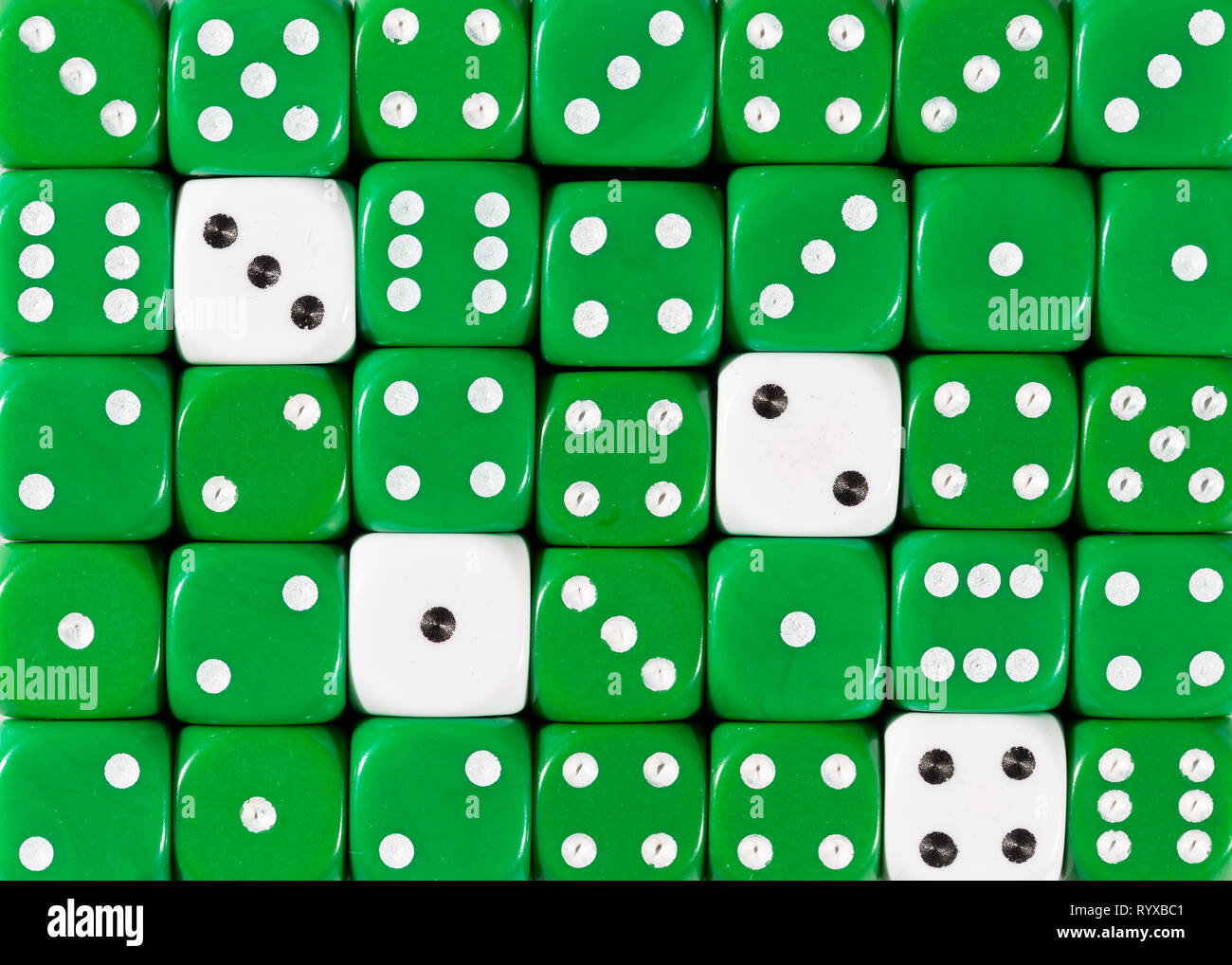 Sullo sfondo di un casuale verde ordinato plinti con quattro cubi bianco Foto Stock