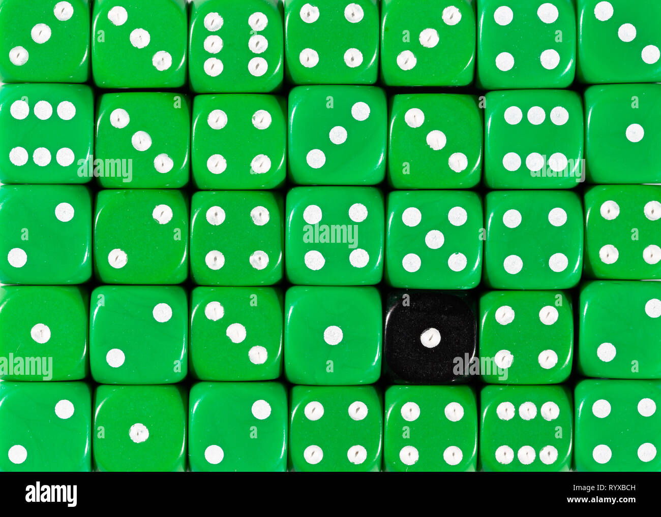 Sullo sfondo di un casuale verde ordinato plinti con un cubo nero Foto Stock
