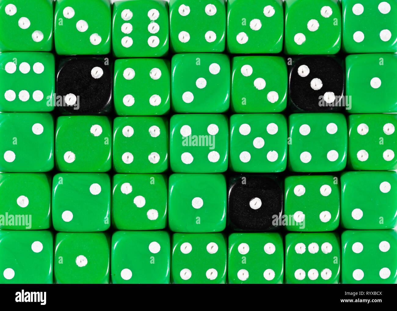 Sullo sfondo di un casuale verde ordinato plinti con tre cubi nero Foto Stock