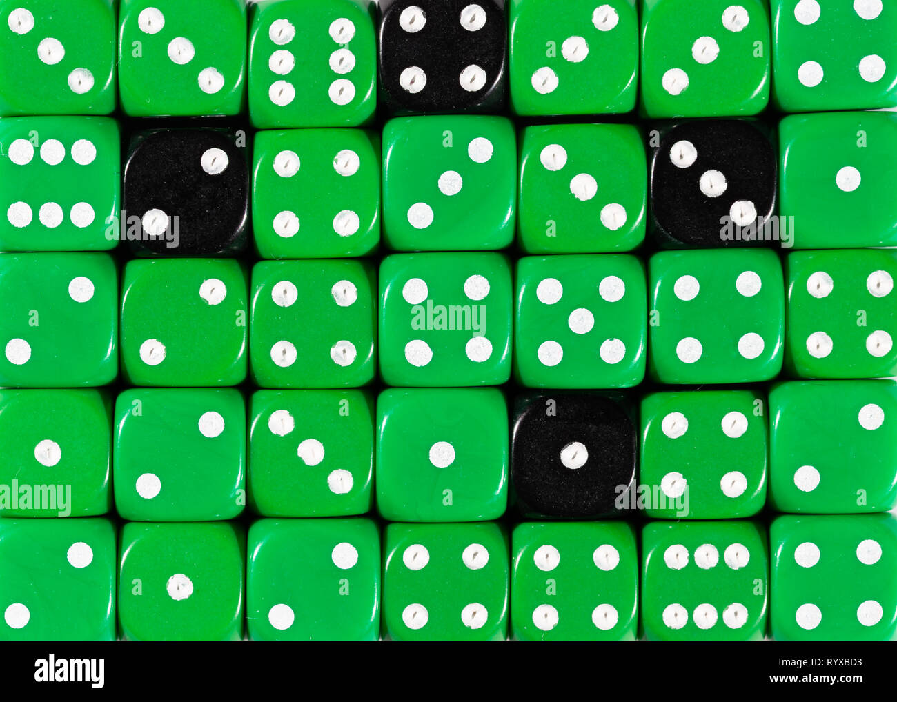 Sullo sfondo di un casuale verde ordinato plinti con quattro cubi nero Foto Stock