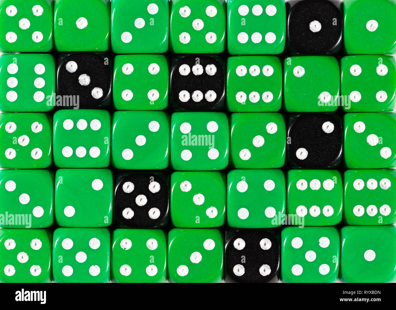 Sullo sfondo di un casuale verde ordinato plinti con sei cubetti di nero Foto Stock