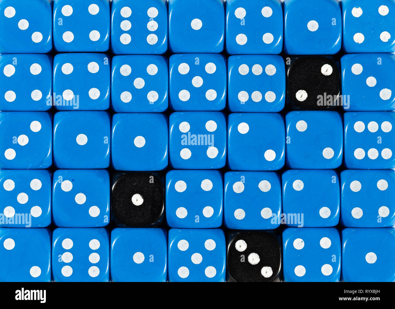 Sullo sfondo di un ordinato casuale dadi blu con tre cubi nero Foto Stock