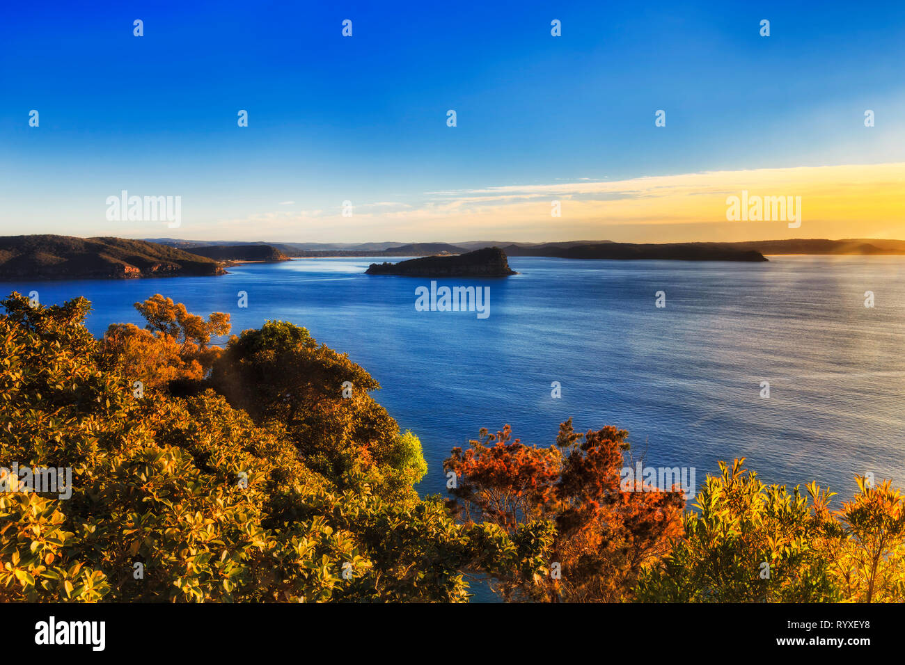 Scenario paesaggistico di Broken Bay quando il fiume Hawkesbury entra nell'Oceano Pacifico con le isole rocciose e il robusto soastline coperto dalla gengiva-alberi in sofm mattina Foto Stock