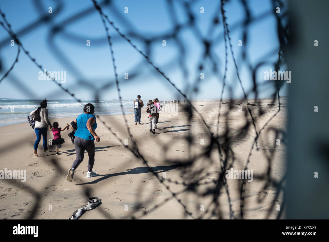 Tijuana, Baja Mexico, Messico. 13 Mar, 2019. Dopo aver infilato attraverso un piccolo foro nel muro di confine dividendo gli Stati Uniti e il Messico, richiedenti asilo sul suolo americano. Mentre alcune persone sono state catturate, pattuglia di confine è stato travolto dalla massa di attraversamento del gruppo e non sono stati in grado di arrestare tutti inizialmente. Nel febbraio 2019, circa 76.000 sono fuggiti dal sud del confine con gli Stati Uniti al fine di trovare una migliore live. Credito: Megan Jelinger SOPA/images/ZUMA filo/Alamy Live News Foto Stock