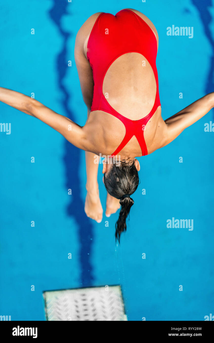 Donna tuffarsi in piscina dal trampolino di lancio. Foto Stock