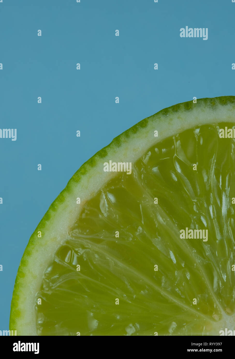 Trimestre di lime slice closeup su sfondo blu Foto Stock