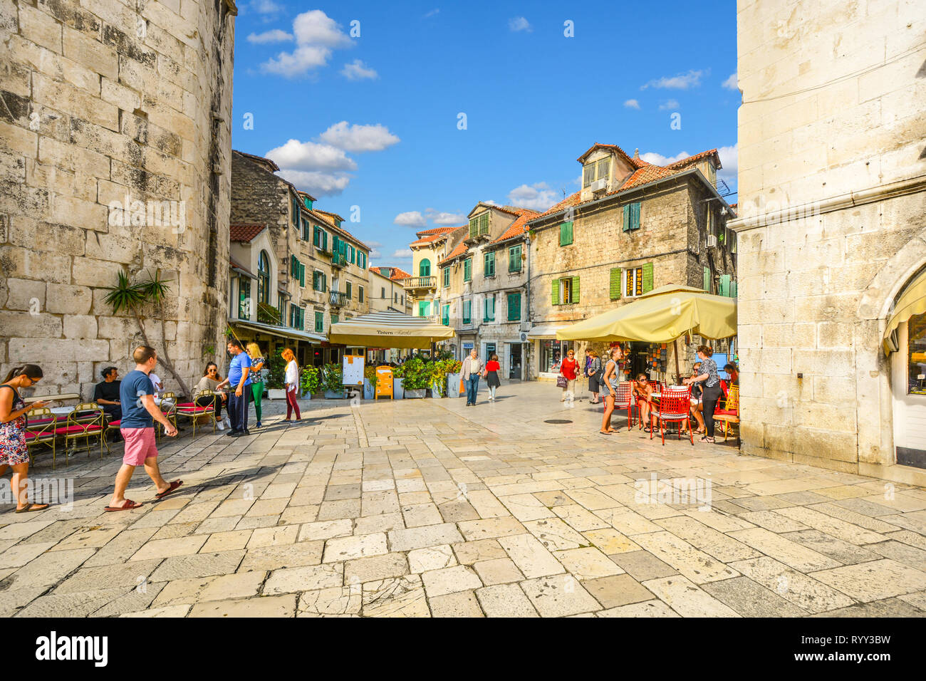 La gente del posto e i turisti si intrecciano in una mattina di sole a inizio autunno presso la piazza di frutta del Palazzo di Diocleziano nell'antica città di Spalato, Croazia. Foto Stock