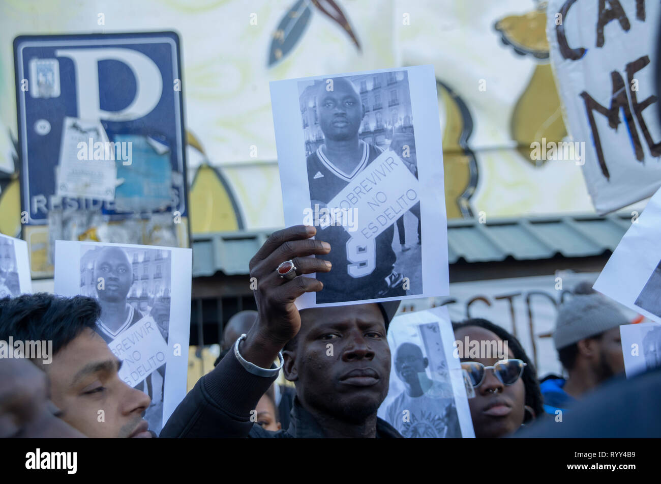 Manifestanti hanno visto con il ritratto del mame Mbaye durante la protesta. La protesta contro il razzismo istituzionale ha avuto luogo a Nelson Mandela Square a Madrid un anno dopo la morte di Mame Mbaye, un senegalese venditore ambulante che morì mentre viene inseguita dalla polizia per la vendita sulle strade. Secondo i manifestanti il giovane non hanno alcun documenti legali pur avendo speso più di dieci anni in Spagna e le autorità non ha aiutato la sua famiglia dopo la sua morte. Essi hanno anche reso omaggio alle vittime della Nuova Zelanda attacco terroristico nelle moschee. Foto Stock