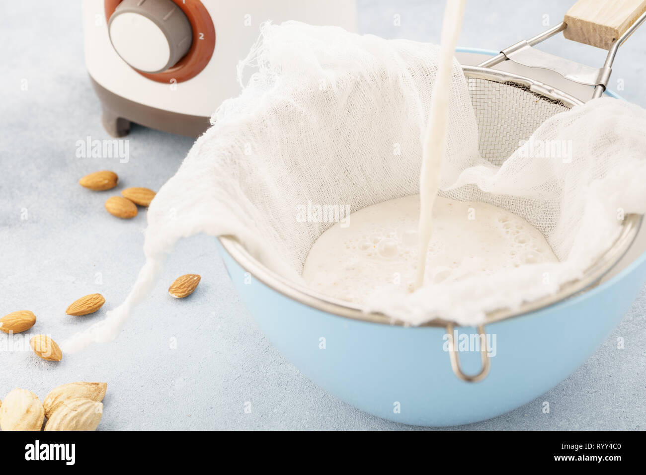 In casa il dado latte rendendo processo. Versare il latte in un panno. Ricetta Step by step. Foto Stock
