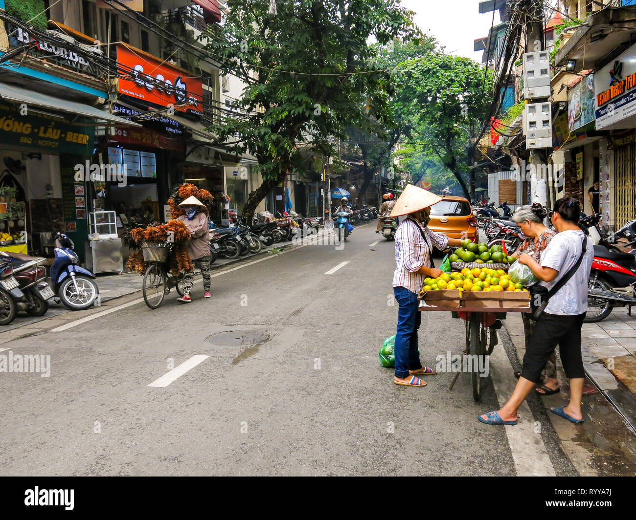 I venditori ambulanti. Scene di strada dalla città vecchia di Hanoi, Vietnam. Foto Stock