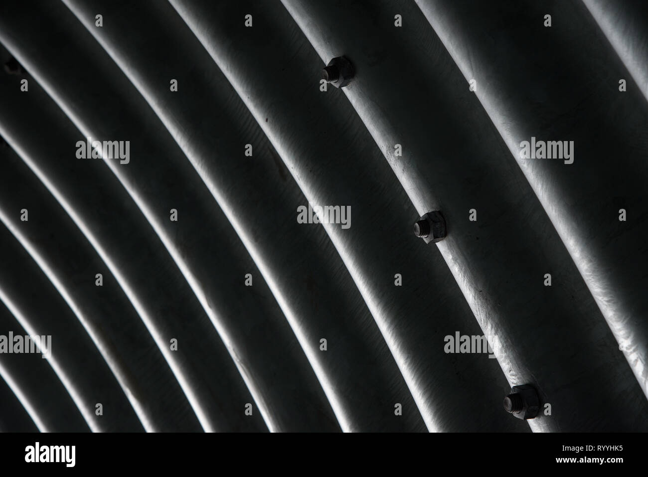 Interno metallico del tunnel, astratta dettaglio con diagonale di buio e di righe luminose monocromatiche, tessitura; onde di metallo sullo sfondo Foto Stock