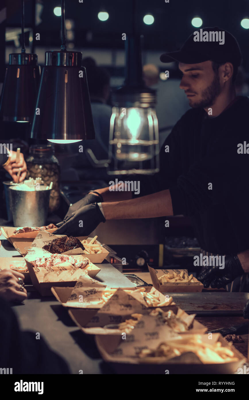 Londra, Inghilterra - Novembre 2018 : gli uomini che serve da asporto fatta in casa i pasti principali sulla strada del mercato alimentare Foto Stock