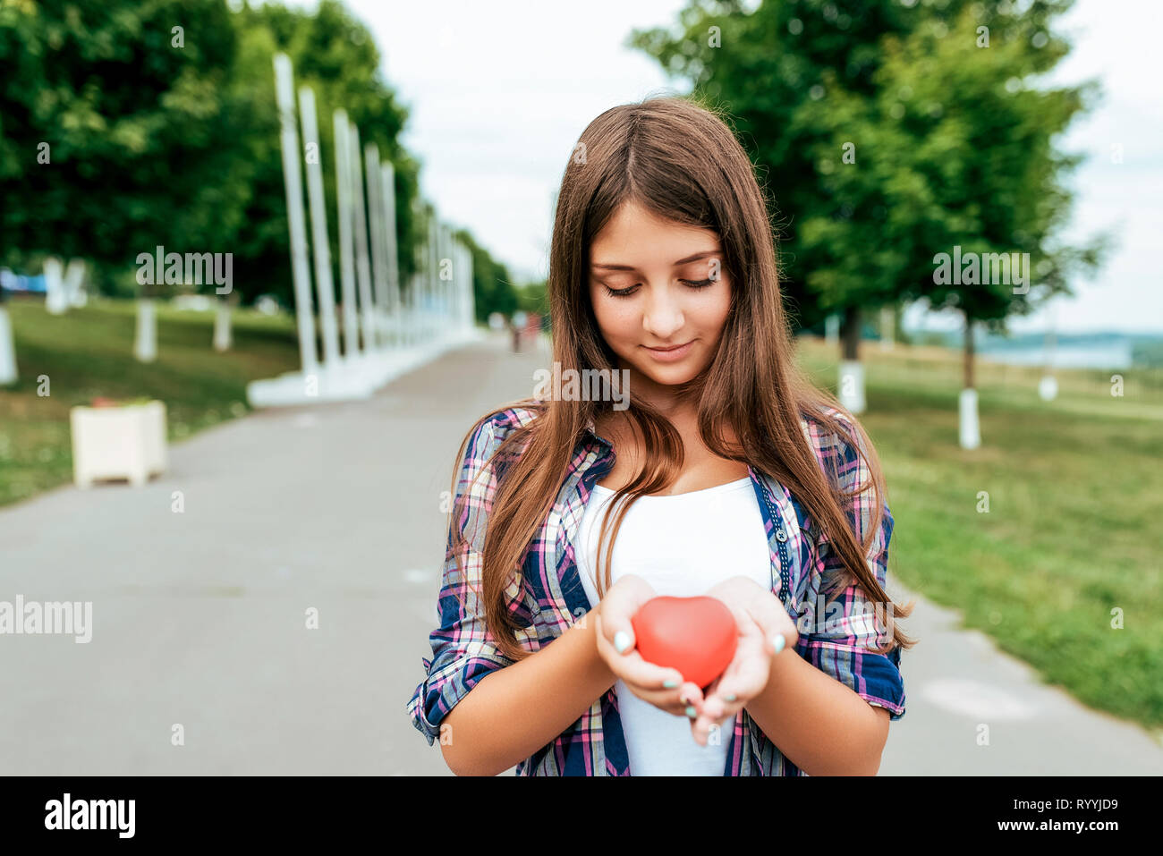 Ragazza schoolgirl 13-16 anni sorge in estate città mani cuore giocattolo.  Spazio libero testo. Felice sorrisi. Concetto di donazione di sangue, vita,  regalo di San Valentino Foto stock - Alamy