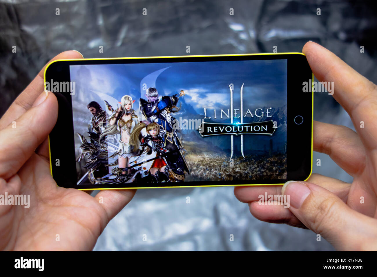 Berdyansk, Ucraina - 16 Marzo 2019: mani di uno smartphone con lineage 2 revolution gioco sullo schermo di visualizzazione. Foto Stock