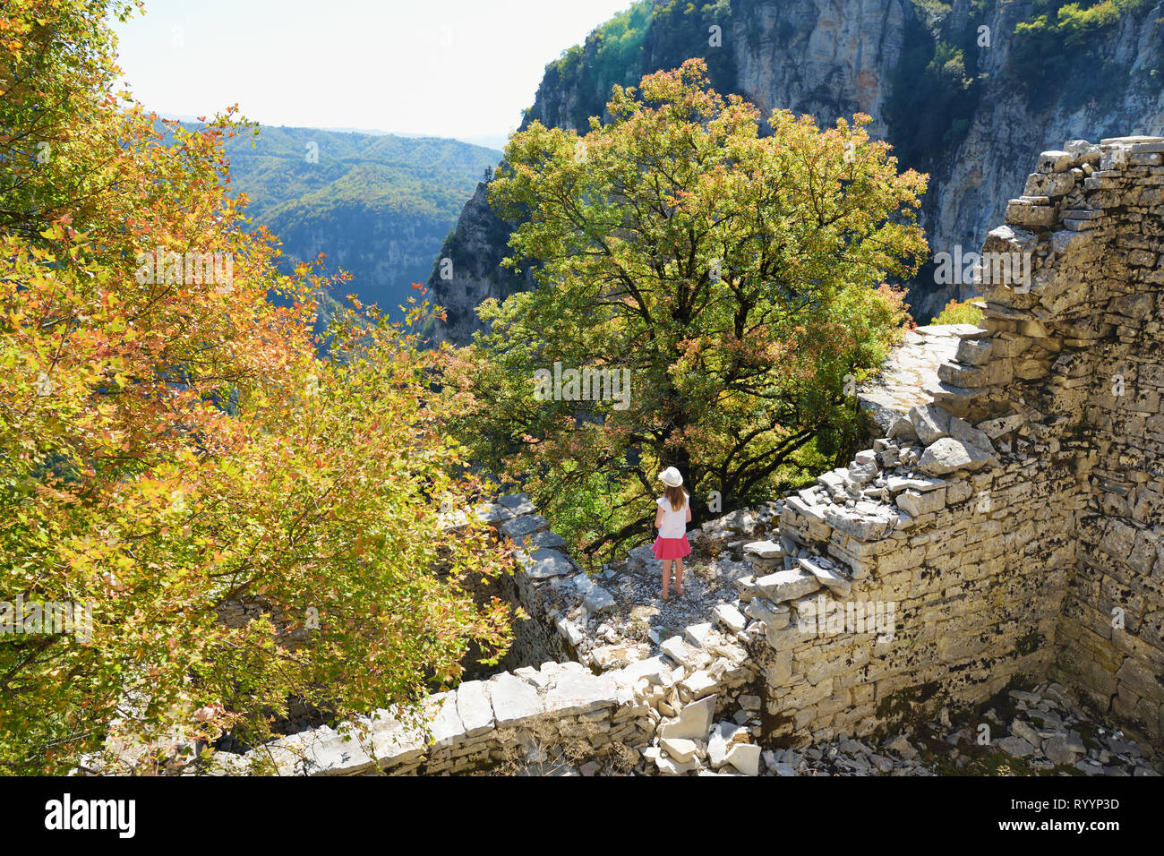 Ragazza giovane esplorare Monodendri village con i suoi tradizionali costruzioni in pietra e camminamenti in pietra, Zagoria area, regione Epiro, il nord-ovest greco Foto Stock