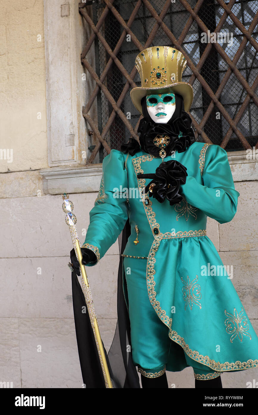 L'uomo vestito di tradizionale maschera e costume per il Carnevale di  Venezia in piedi al palazzo ducale di Piazza San Marco, Venezia, Veneto,  Italia Foto stock - Alamy