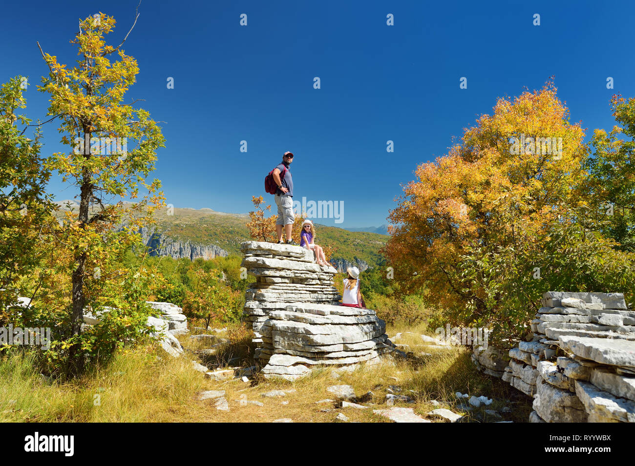 Il padre e i bambini ad esplorare la Foresta di Pietra, formazione rocciosa naturale, creato da più strati di pietra, situato vicino al villaggio di Monodendri Zagori nella regione, Foto Stock