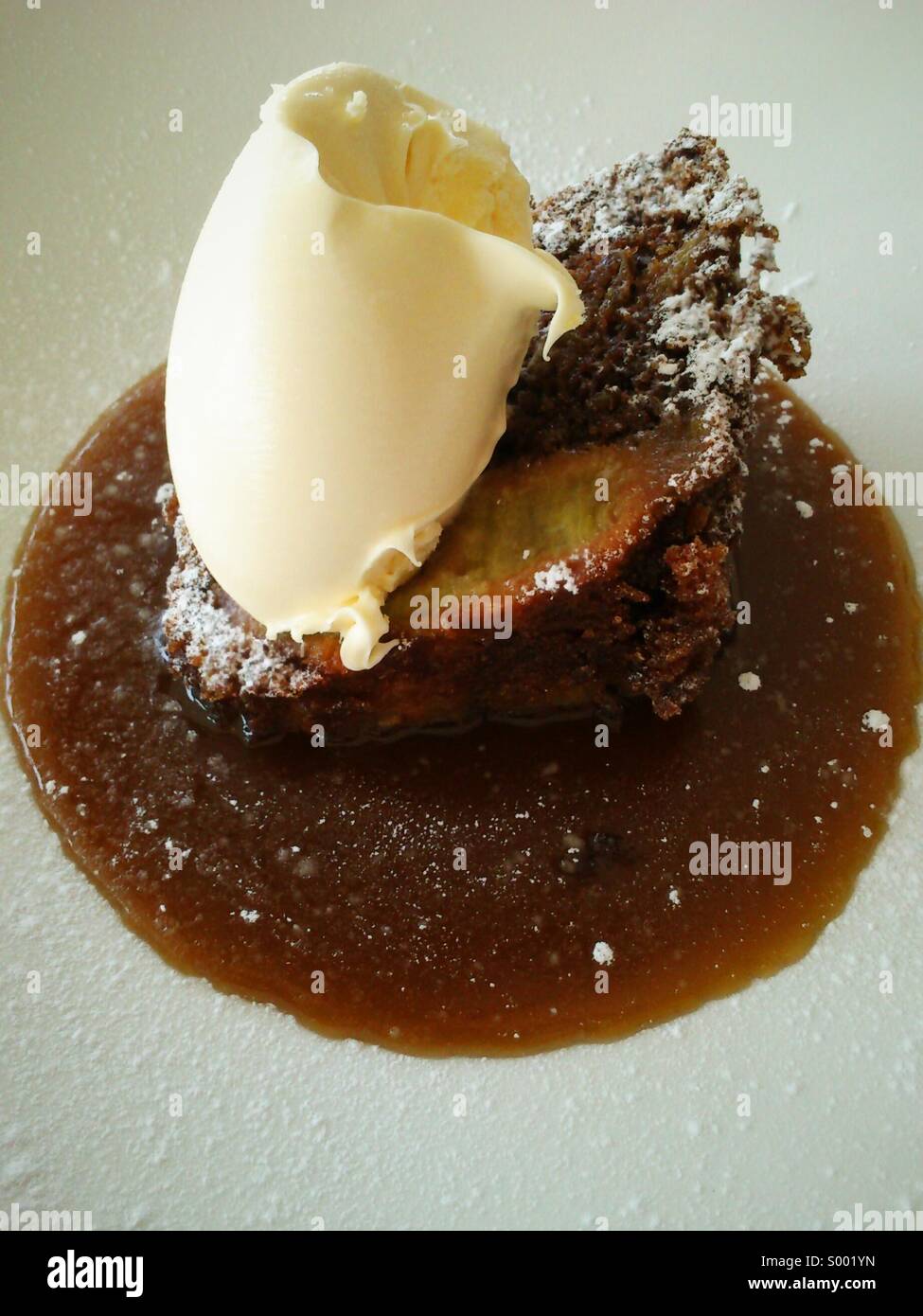 Pera e zenzero torta con clotted cream e toffee salsa. - Immagine stock catturata con smartphone