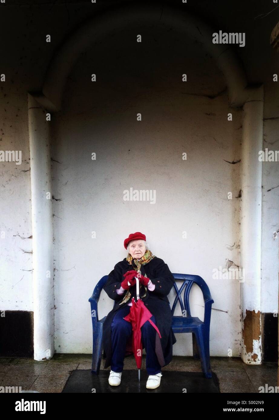 Senior lady, donna di età 80-85 seduta sul banco di prova, all'aperto Foto Stock