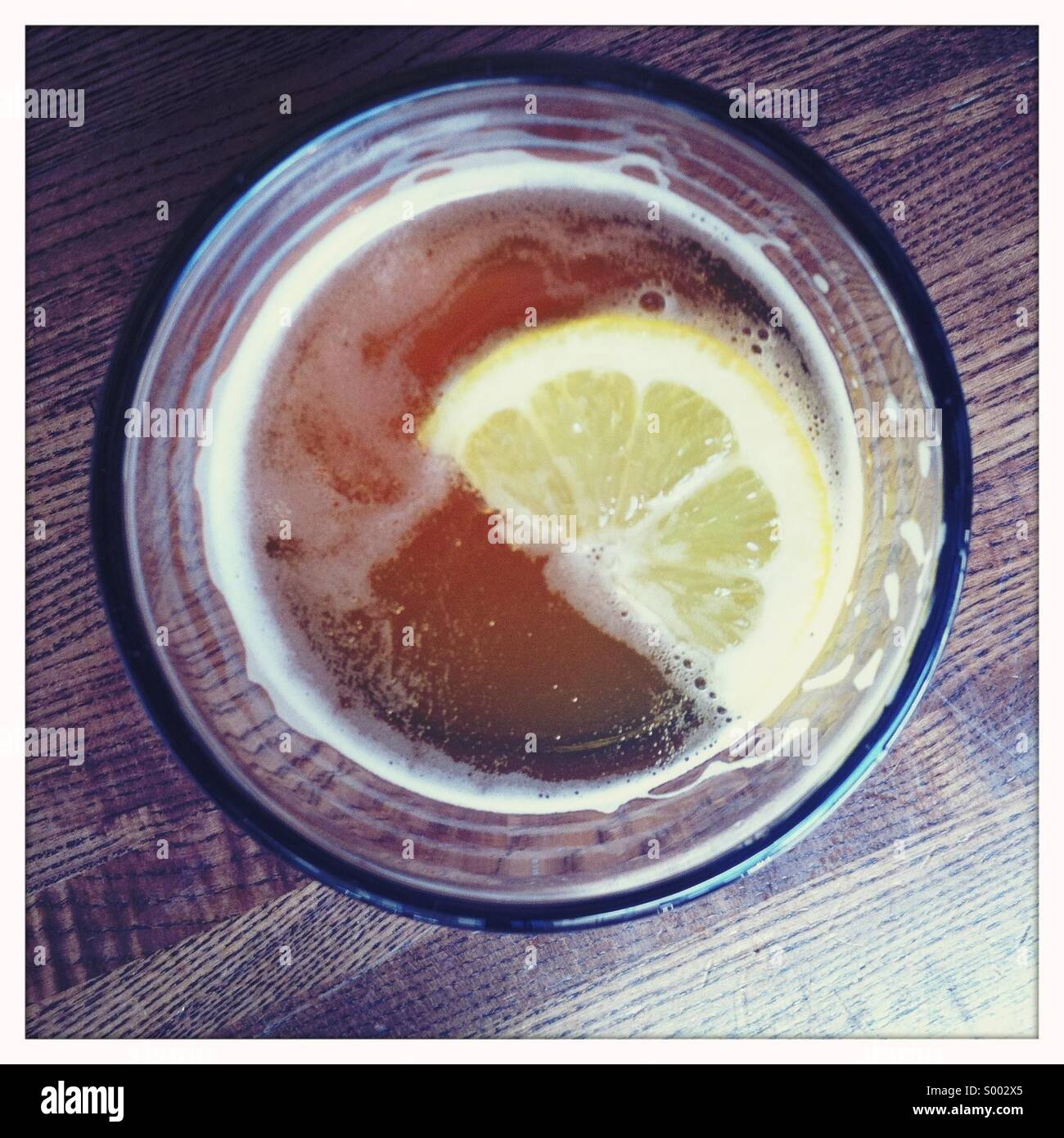 Cerca in un bicchiere di birra con un cuneo di limone Foto Stock