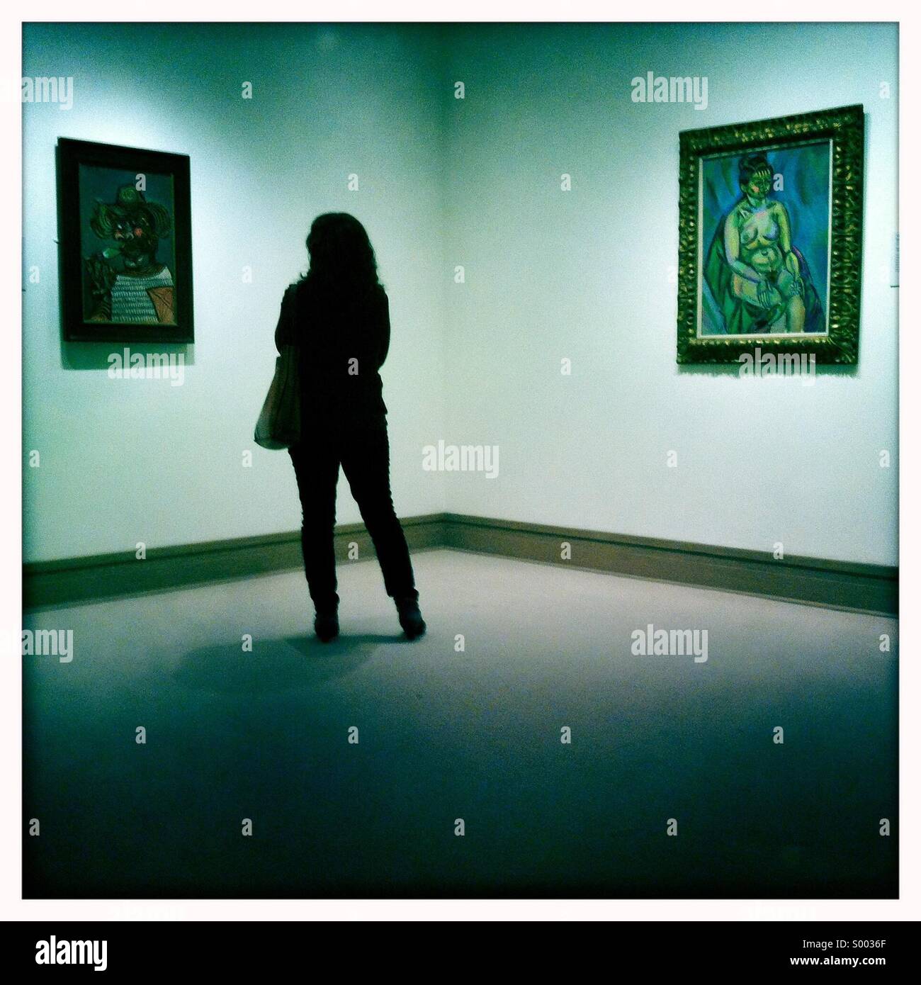 Una donna guardando le opere in un museo Foto Stock
