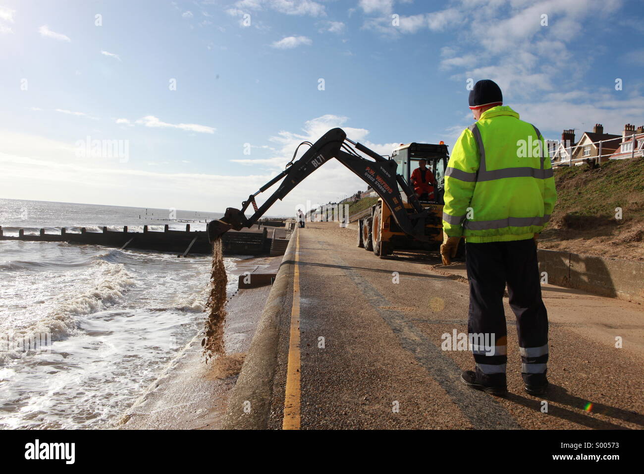 Operai sabbia chiara off Southwold Promenade seguenti tempeste invernali Foto Stock