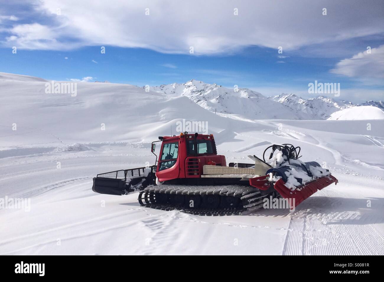 Rosso moderno toelettatore di neve sul versante vuoto - Immagine stock catturata con smartphone