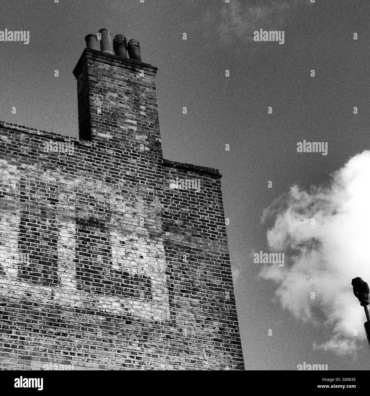 Nero e bianco edificio di mattoni con testo contro un cielo Foto Stock