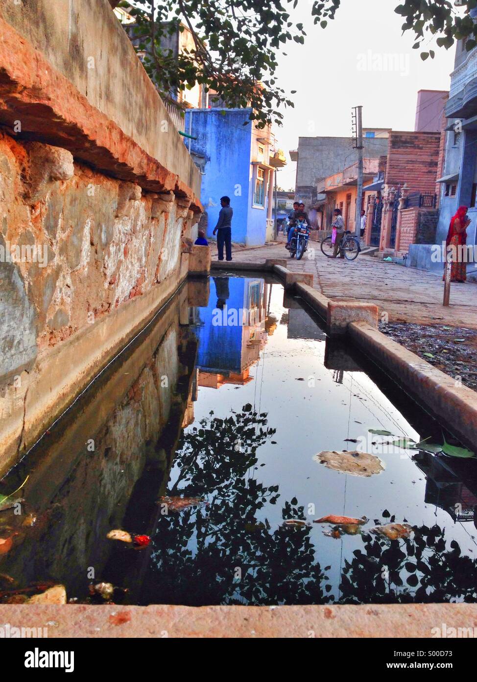 Trogolo di acqua in un villaggio indiano con riflessioni - Immagine stock catturata con smartphone Trogolo di acqua in un villaggio indiano con riflessioni - Immagine stock catturata con smartphone