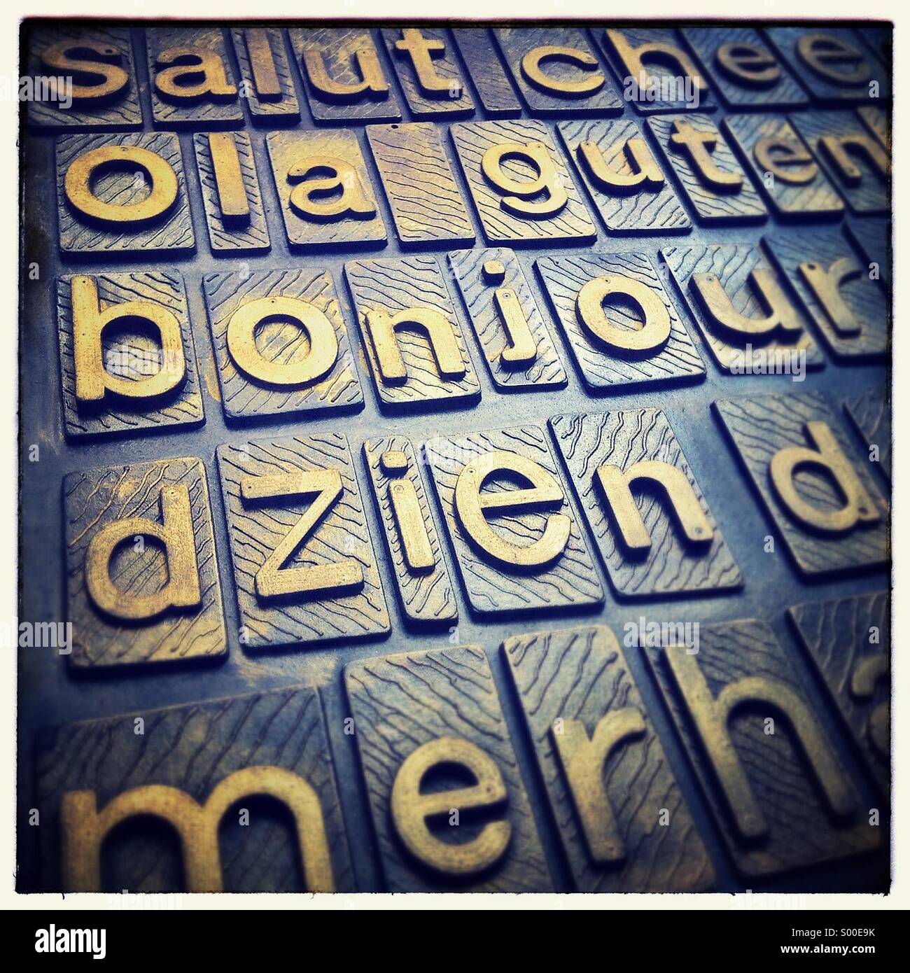 I saluti nelle diverse lingue su un golden tipography moquette. Foto Stock