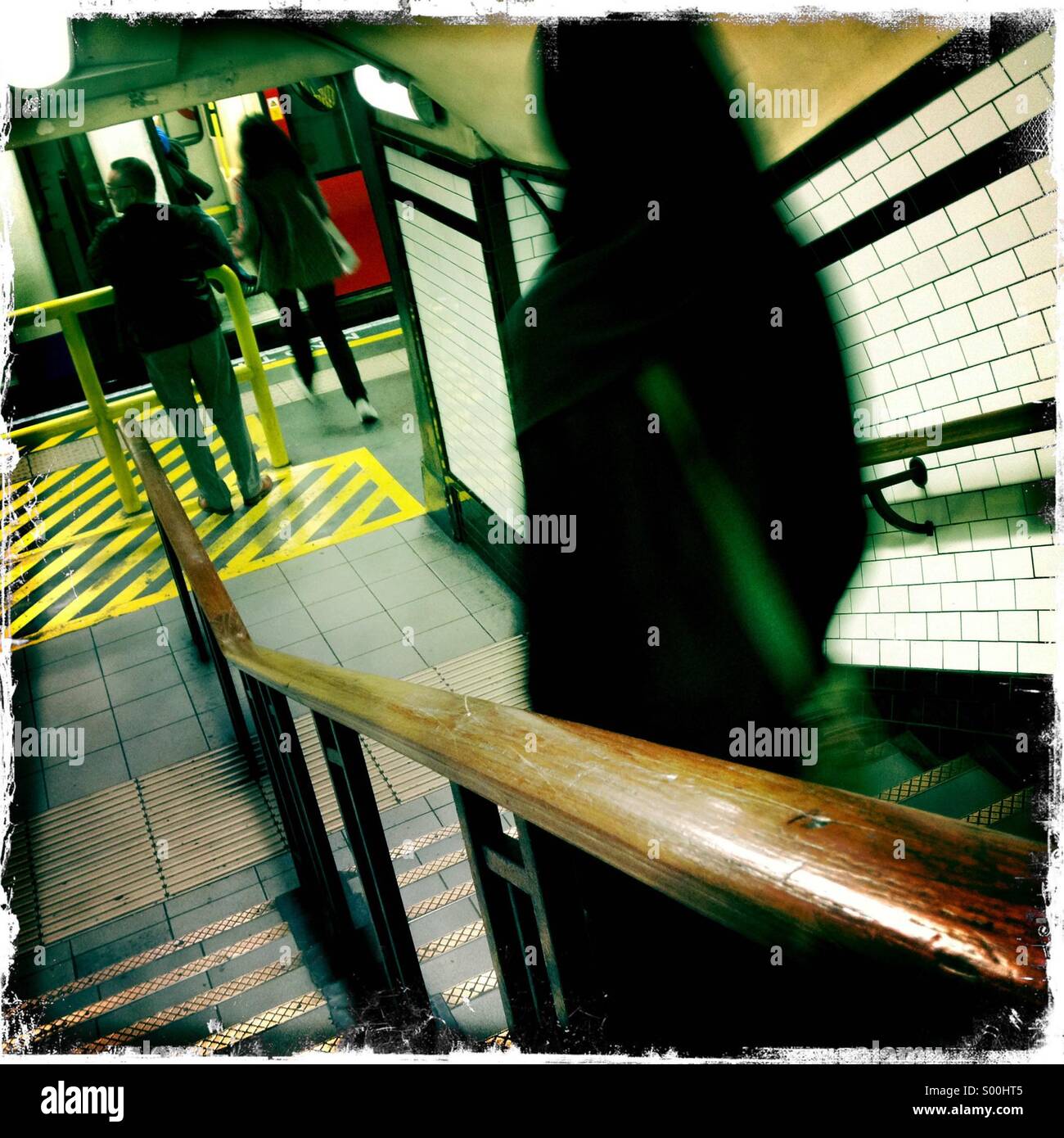 Camden stazione della metropolitana di Londra. Passeggeri a piedi giù per le scale sulla piattaforma di tubo. Treno del tubo in corrispondenza della piattaforma. Foto Stock