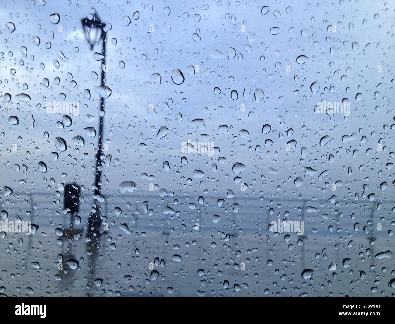 Gocce di pioggia sul vetro guardando al mare - Immagine stock catturata con smartphone