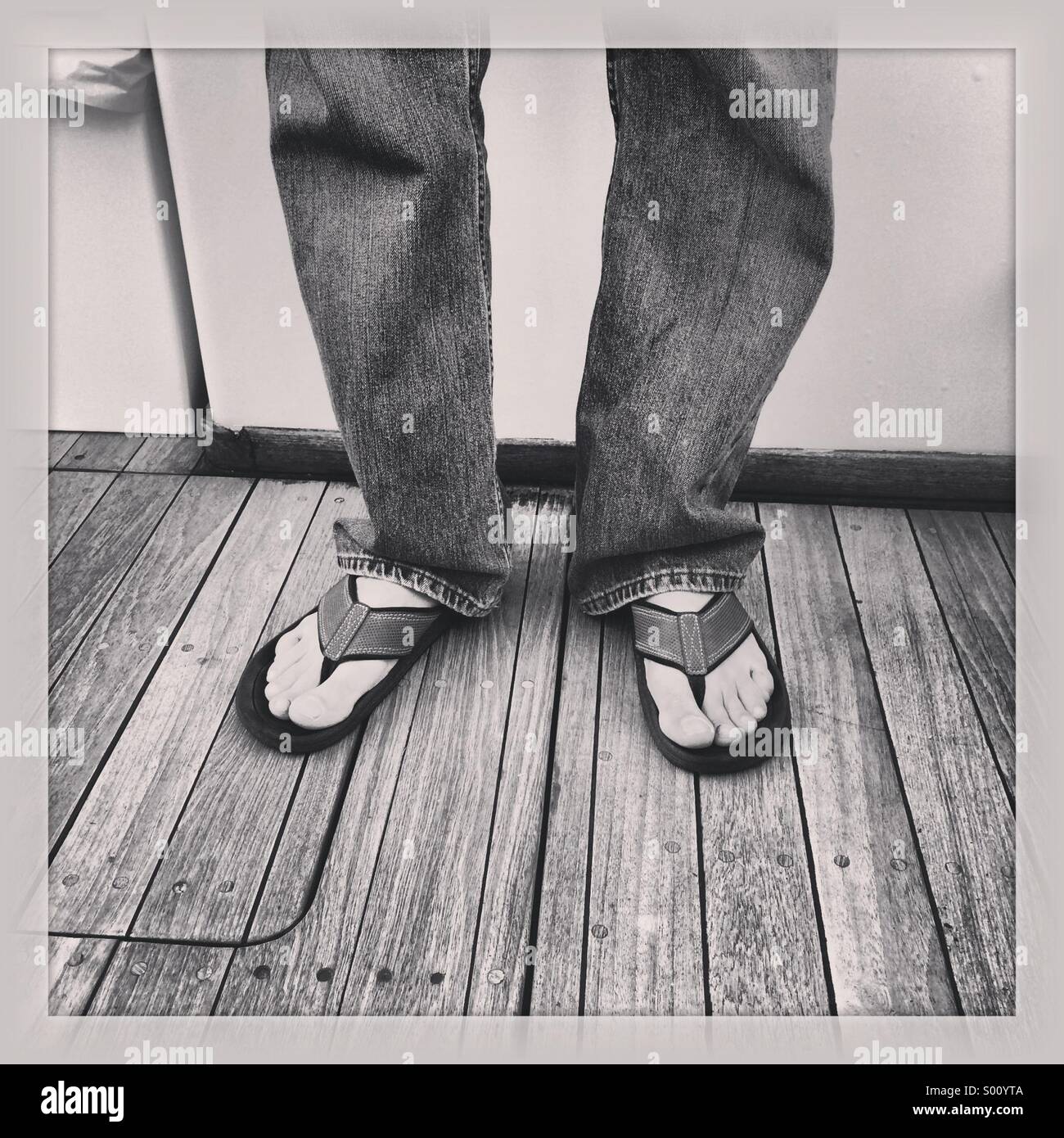 L uomo indossa sandali su una barca durante l'estate Foto stock - Alamy