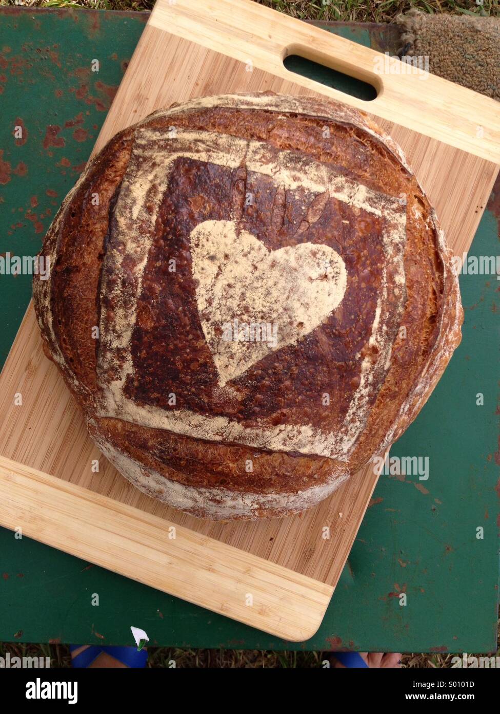 Pane appena sfornato di pasta acida pane fatto con amore completo con a forma di cuore sulla crosta Foto Stock