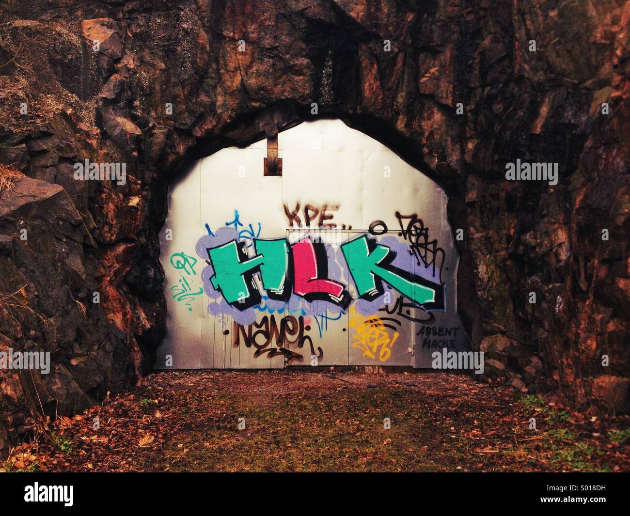 I graffiti sulla porta di metallo nella parete di roccia. Foto Stock