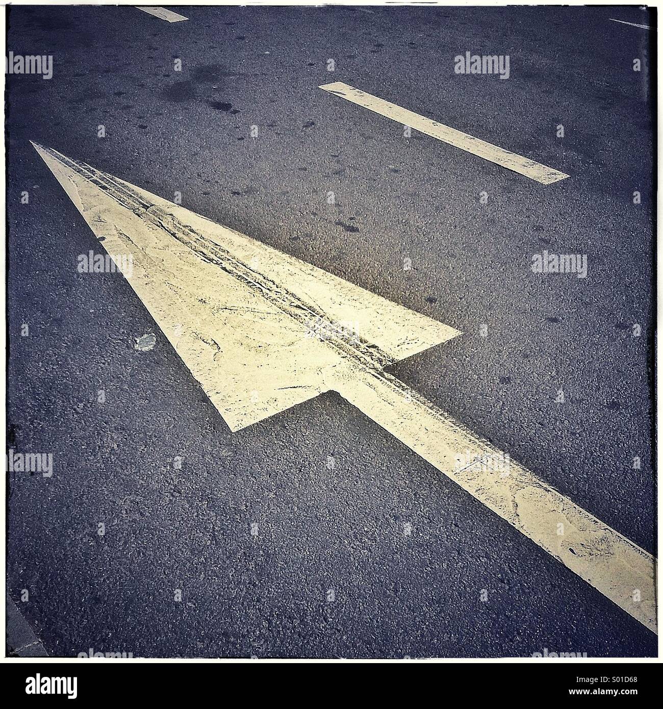 La freccia sulla strada asfaltata, una direzione segno di traffico Foto Stock
