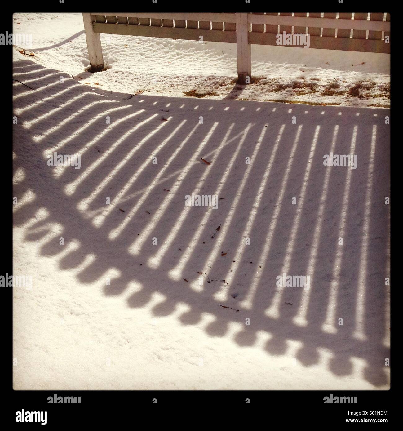 L ombra di una recinzione sulla neve in basso sole invernale... Foto Stock