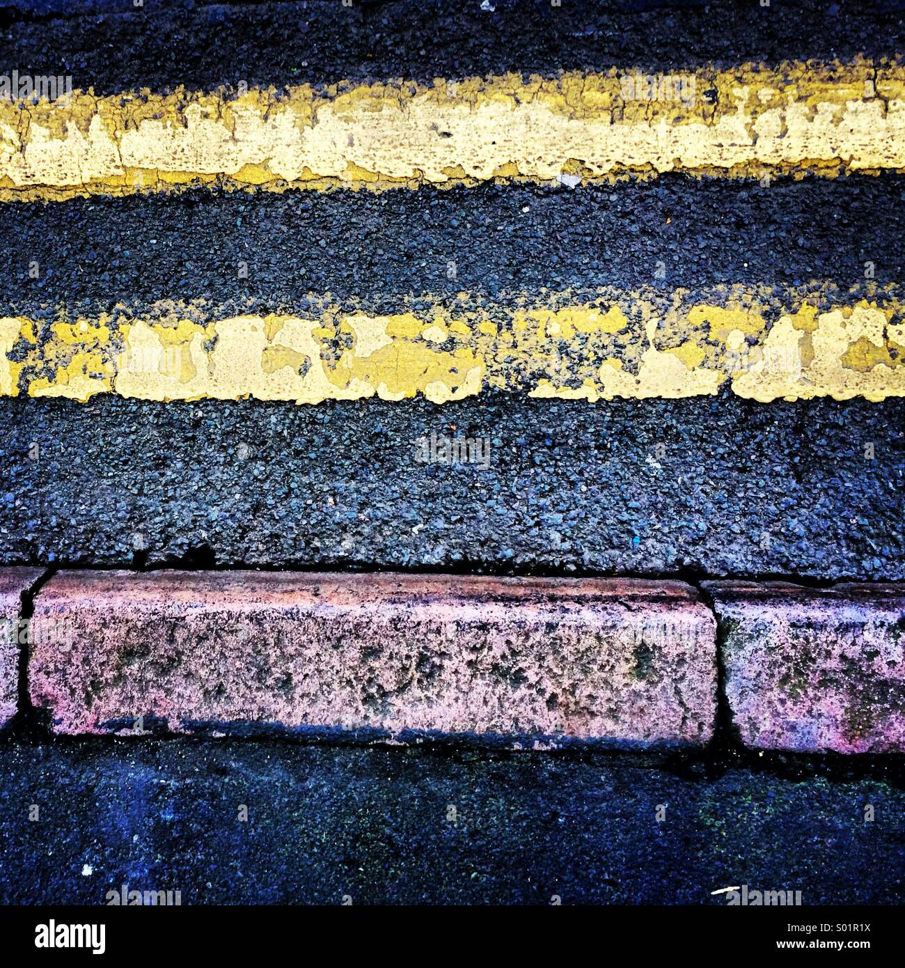 Doppie linee di colore giallo e il cordolo di marciapiede. Foto Stock