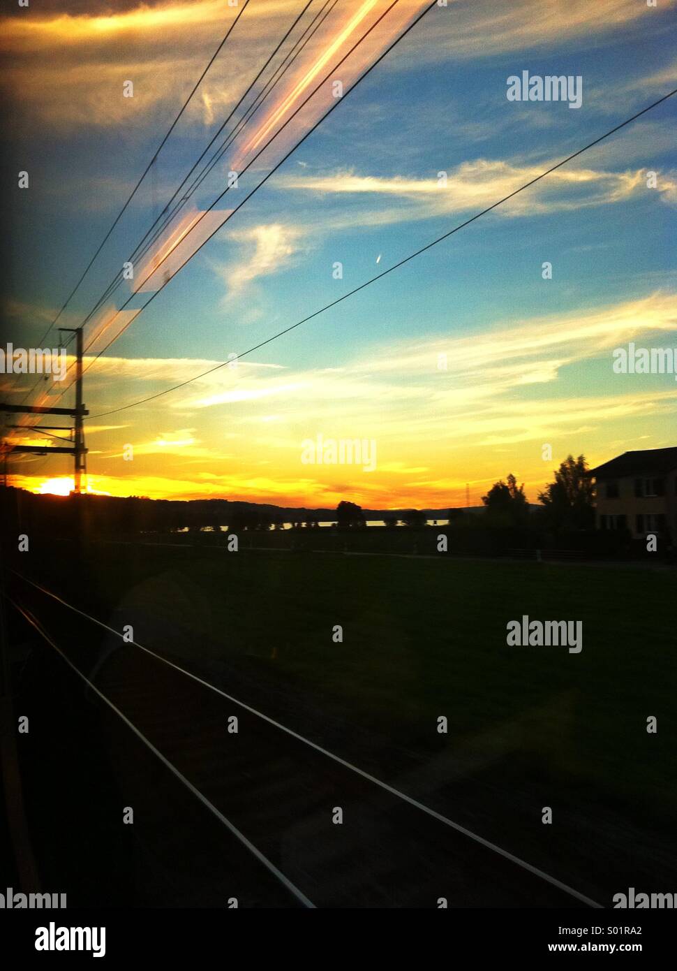 Treno traccia le linee di potenza tramonto Foto Stock