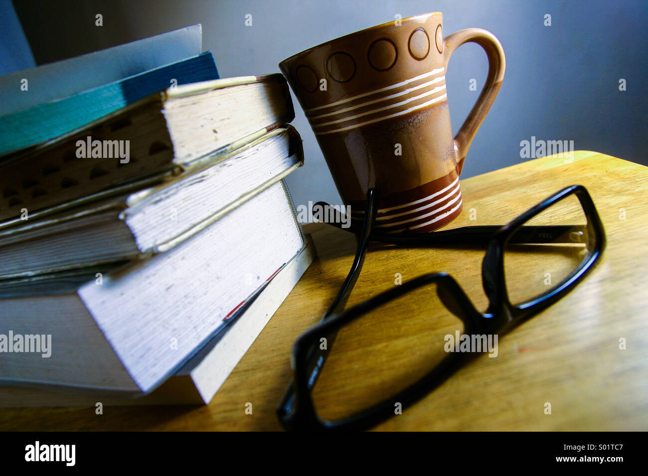 Libri, caffè e occhiali Foto Stock