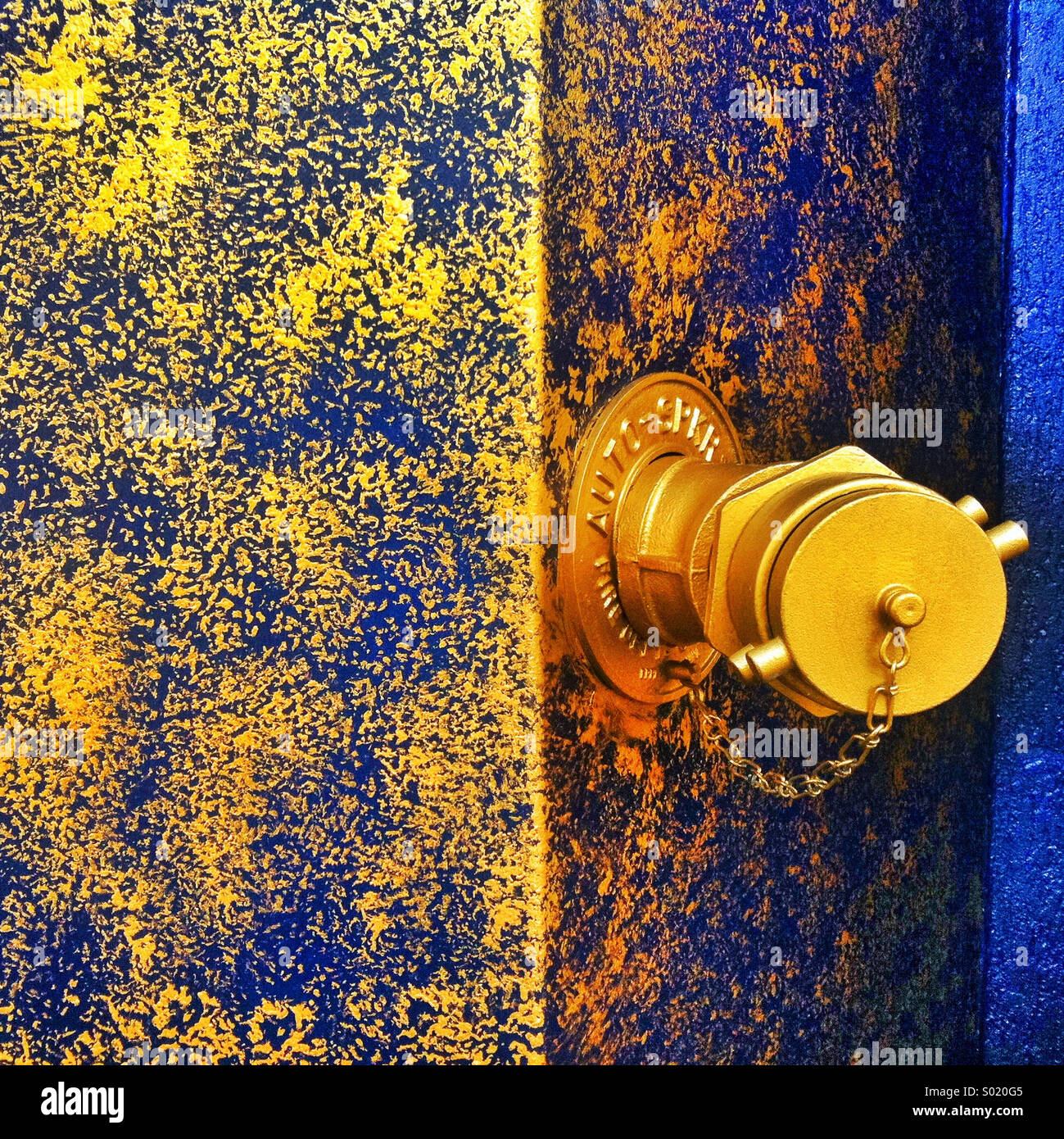 Un oro acqua codolo sporgente da un edificio blu verniciato con vernice dorata Foto Stock