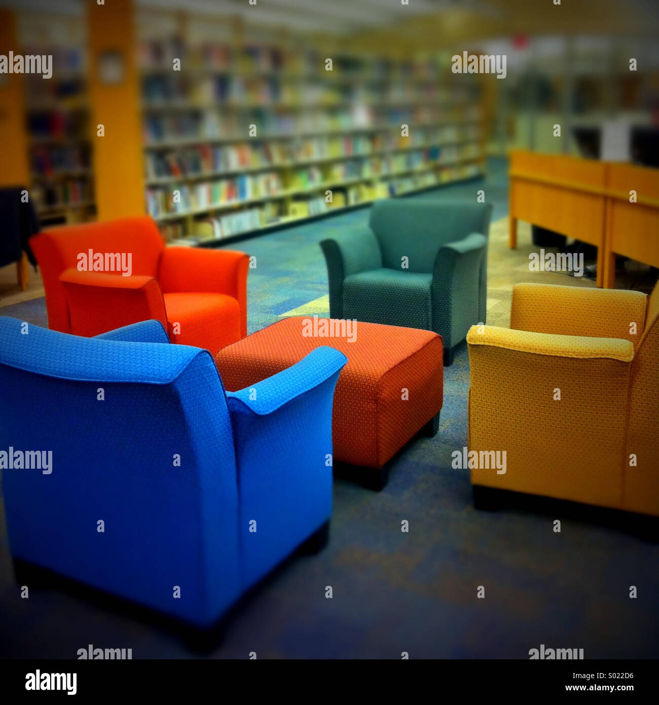 Grande e colorata poltrone in una libreria Foto Stock