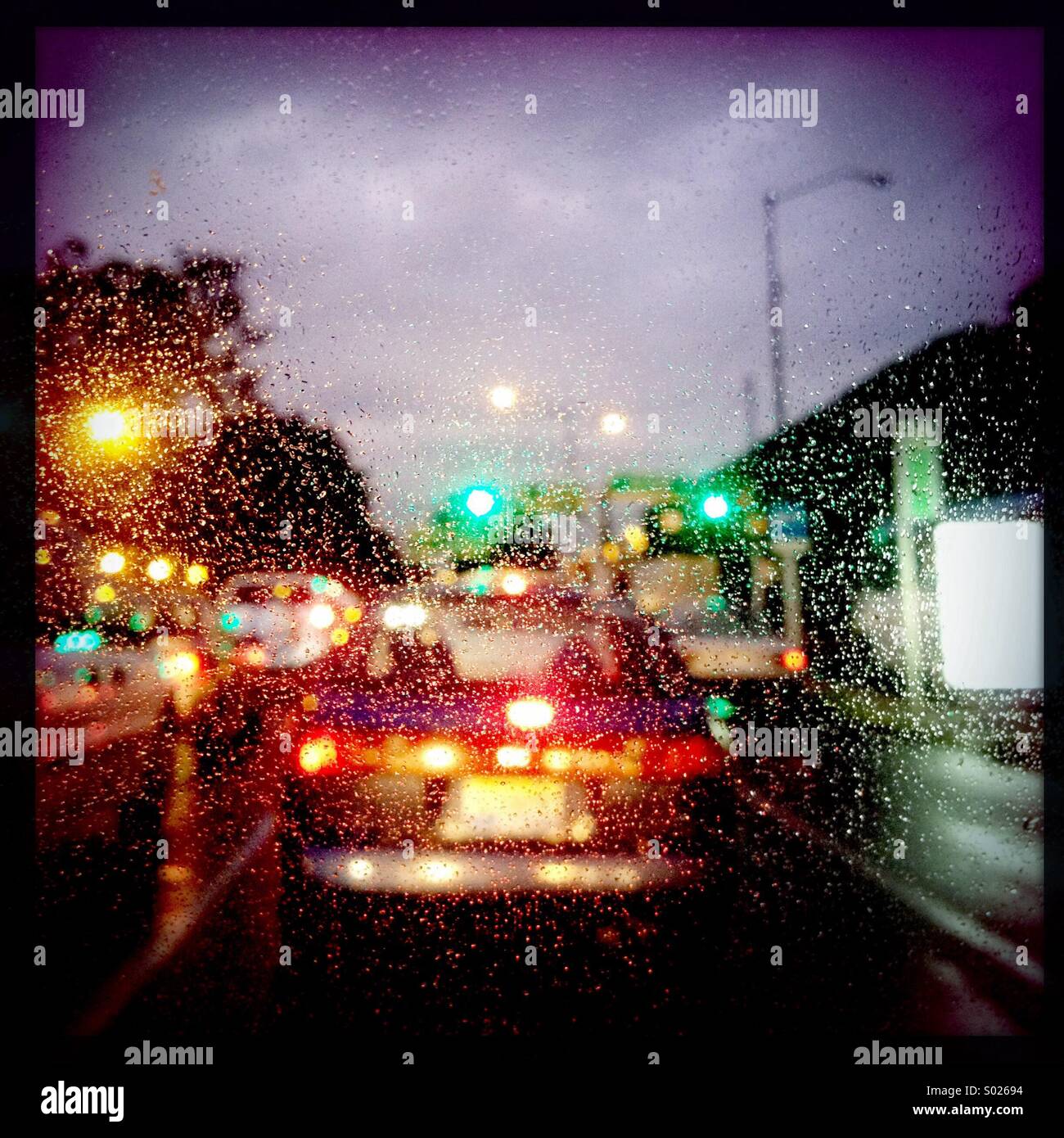 Traffico sotto la pioggia di notte Foto Stock