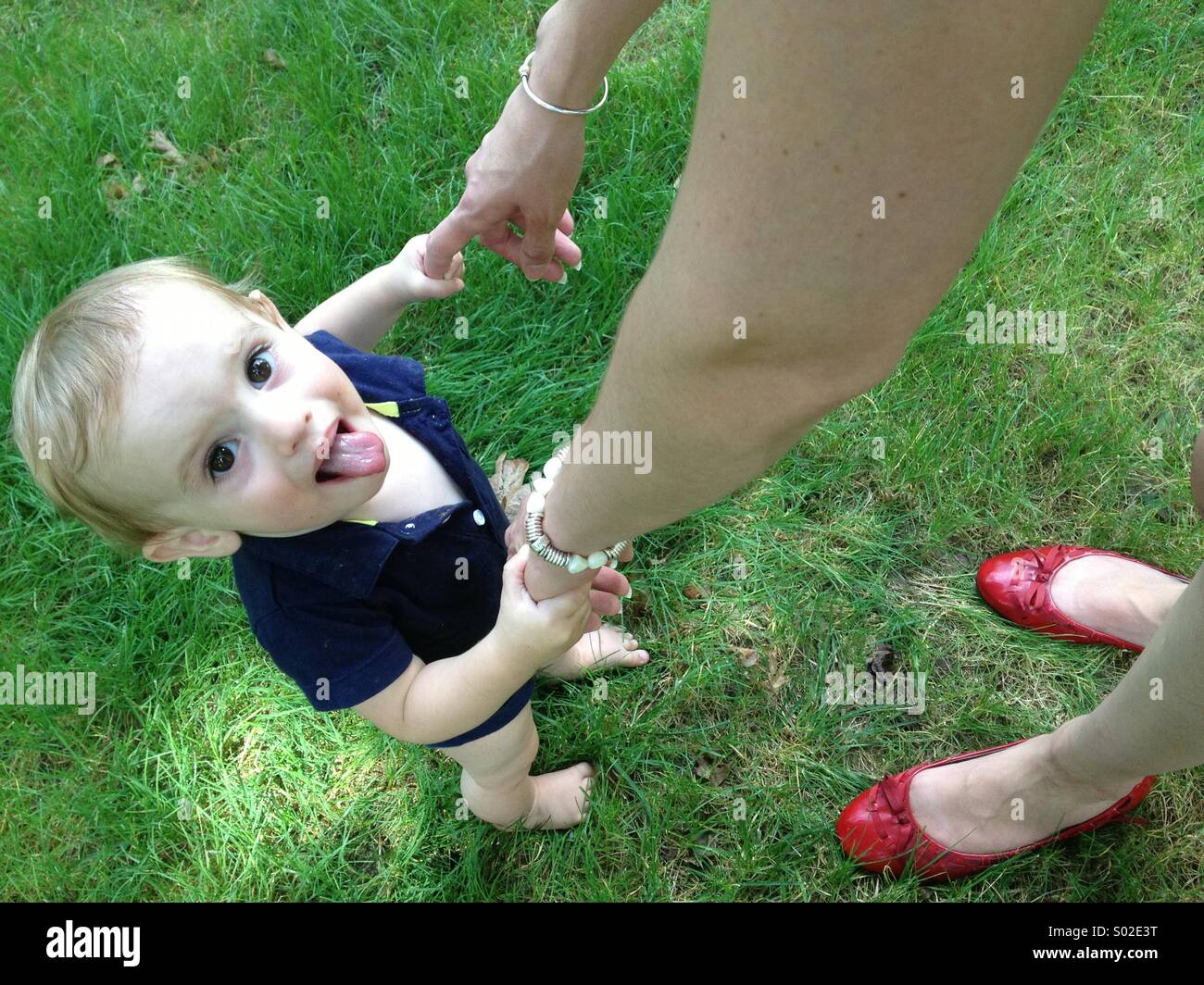 Baby boy i primi passi con la mamma in estate. Foto Stock