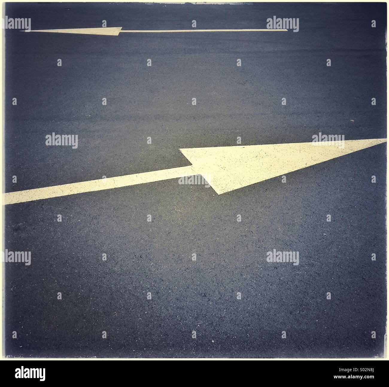 Dipinto di bianco opposto segno di freccia su asfalto - Immagine stock catturata con smartphone